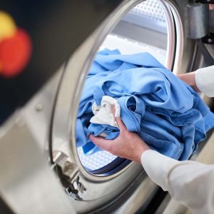 Hands to load the Laundry in the washing machine at the dry cleaners